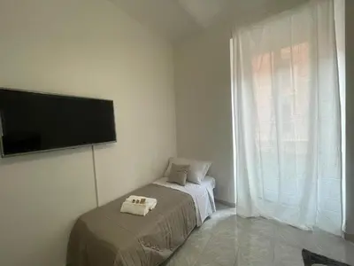 a bedroom with a bed and a flat screen tv at San Lorenzo Private Apartment in Rome