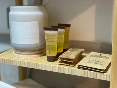 a shelf with two rolls of toilet paper and a vase at San Lorenzo Private Apartment in Rome