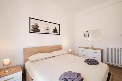 a bedroom with a white bed and two night stands at Ospedale Gemelli-Vaticano Domus Di Pace 1BDR by Hôtea in Rome