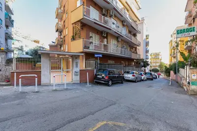 a parking lot with cars parked in front of a building at HYRIA Holiday Home in Rome