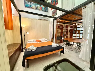 a bedroom with a bed and a desk and a table at L'atelier - mostra sospesa in Rome