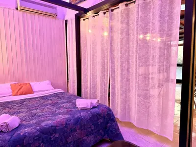 a bedroom with a bed and a window with curtains at L'atelier - mostra sospesa in Rome