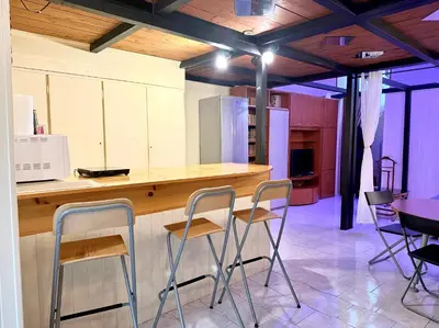 a kitchen with a counter and stools in a room at L'atelier - mostra sospesa in Rome
