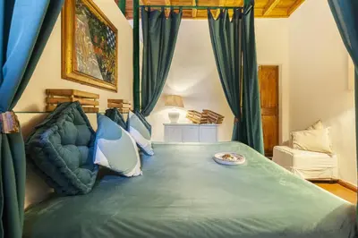 a bedroom with a large bed with blue curtains at Campo dei Fiori Luxury Gold in Rome