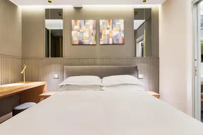a bedroom with a large white bed and two mirrors at Spanish Steps Modern Gem in Rome