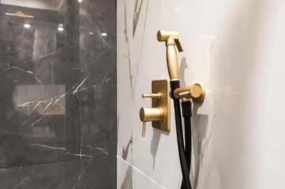 a black cord plugged into a wall with a brass handle at Spanish Steps Modern Gem in Rome