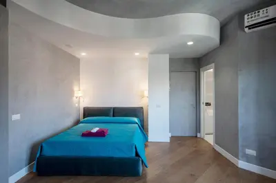 a bedroom with a blue bed with a red bag on it at Domus DiDio in Rome