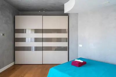 a bedroom with a blue bed and a closet at Domus DiDio in Rome