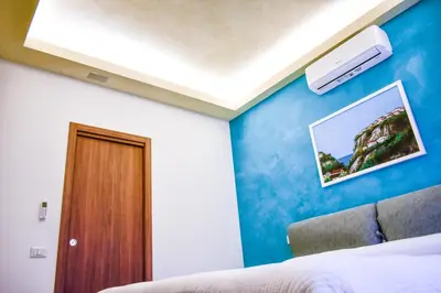 a bedroom with a blue wall with a bed and a ceiling at Domus DiDio in Rome
