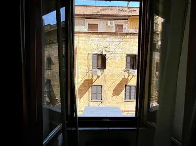 an open window with a view of a building at Dreams Under the Trees - Metro Roma Termini in Rome
