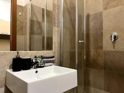 a bathroom with a white sink and a shower at Dreams Under the Trees - Metro Roma Termini in Rome