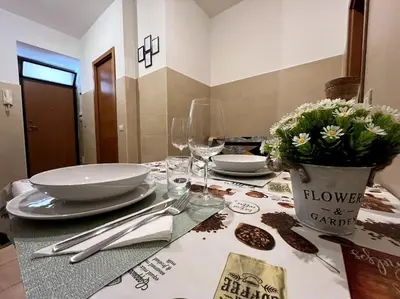 a table with plates and glasses and flowers on it at Dreams Under the Trees - Metro Roma Termini in Rome