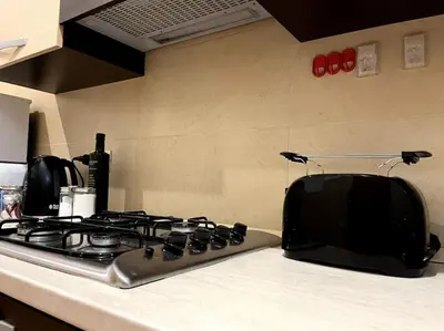 a kitchen counter with a stove and a microwave at Dreams Under the Trees - Metro Roma Termini in Rome