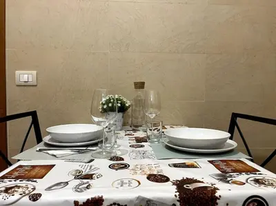 a table with plates and glasses on top of it at Dreams Under the Trees - Metro Roma Termini in Rome