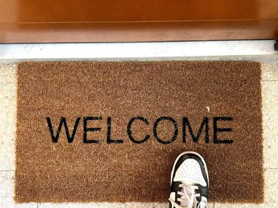 a persons shoe on a welcome mat with a welcome sign at Dreams Under the Trees - Metro Roma Termini in Rome