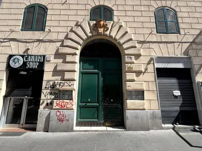 a building with a green door with a dog above it at Dreams Under the Trees - Metro Roma Termini in Rome