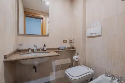 a bathroom with a sink and a toilet and a mirror at Exclusive Campo dei Fiori Flat in Rome