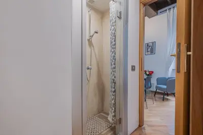 a bathroom with a walk in shower next to a door at Exclusive Campo dei Fiori Flat in Rome
