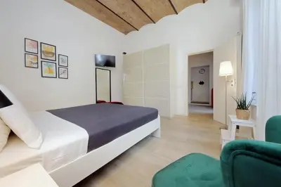 a bedroom with a bed and a green chair at Colosseo Mon Amour in Rome