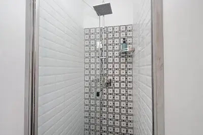 a bathroom with a shower with a glass door at Colosseo Mon Amour in Rome