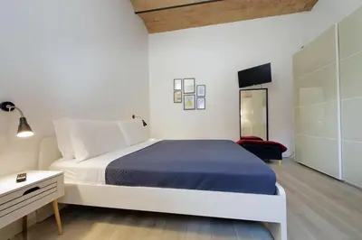 a white bedroom with a bed and a dresser at Colosseo Mon Amour in Rome