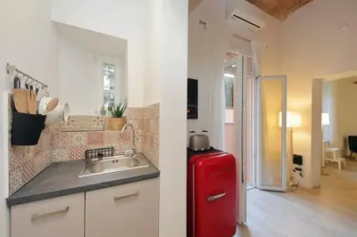 a kitchen with a sink and a red refrigerator at Colosseo Mon Amour in Rome