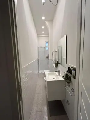 a white bathroom with a sink and a mirror at Appartamento Ostiense CasaFrai in Rome