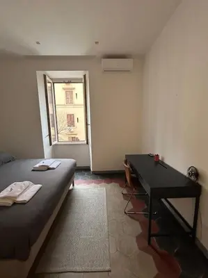 a room with a bed and a desk and a window at Appartamento Ostiense CasaFrai in Rome