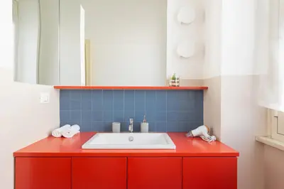 a bathroom with a red vanity with a white sink at La Stella Apartment by Hostand in Rome