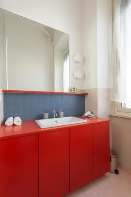 a red bathroom with a sink and a mirror at La Stella Apartment by Hostand in Rome