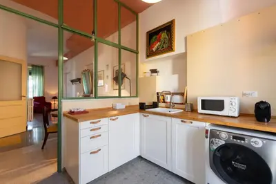 a kitchen with a washing machine and a microwave at La Stella Apartment by Hostand in Rome