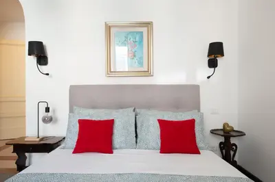 a bedroom with a bed with red pillows at La Stella Apartment by Hostand in Rome