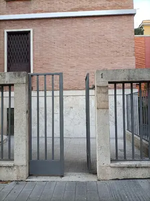 two metal gates in front of a brick building at La Stella Apartment by Hostand in Rome