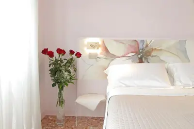 a bedroom with a bed with a vase of red roses at On Rome Affittacamere o GuestHouse in Rome