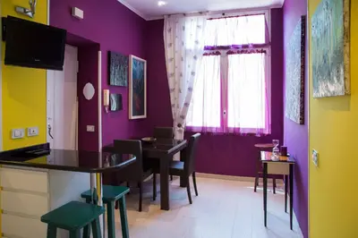a dining room with purple walls and a table and chairs at Violet House in Rome