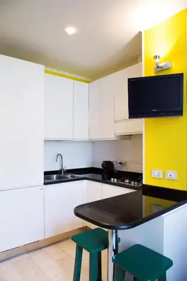 a kitchen with a table and two green stools at Violet House in Rome