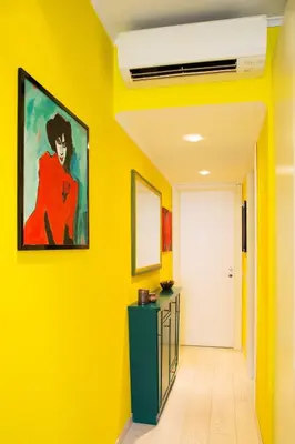a hallway with yellow walls and a painting on the wall at Violet House in Rome