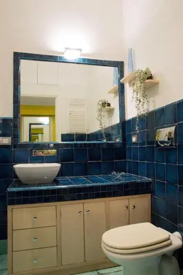 a blue tiled bathroom with a sink and a toilet at Violet House in Rome