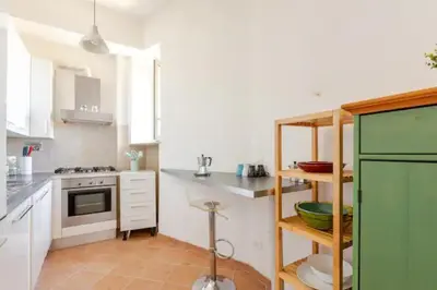 a kitchen with white cabinets and a green refrigerator at Porta Maggiore Cozy Apartment in Rome