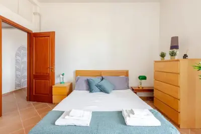 a bedroom with a large bed with blue pillows at Porta Maggiore Cozy Apartment in Rome