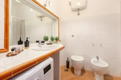a bathroom with a sink and a toilet and a mirror at Porta Maggiore Cozy Apartment in Rome