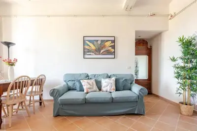 a living room with a blue couch and a table at Porta Maggiore Cozy Apartment in Rome