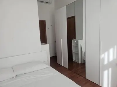 a bedroom with a white bed and a mirror at Aris Square Rome in Rome