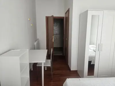a white room with a desk and a bedroom at Aris Square Rome in Rome