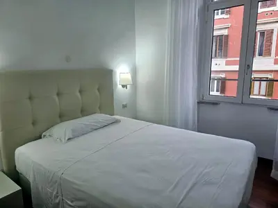 a bedroom with a large white bed with a window at Aris Square Rome in Rome
