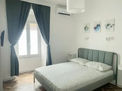 a bedroom with a bed with blue curtains and a window at Apartment 29 in Rome