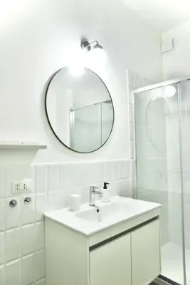a white bathroom with a sink and a mirror at Apartment 29 in Rome