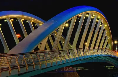 a blue bridge with a person on it at night at Sina Rent Room Flaminio in Rome