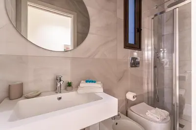 a bathroom with a sink and a toilet and a mirror at iFlat Campo dei Fiori View and SPA in Rome