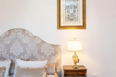 a chair in a room with a lamp on a table at Amazing Domus Ruspoli in Rome